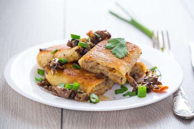 fried thin pancakes stuffed with meat and mushrooms