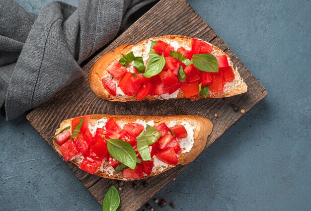 Fried toast with tomatoes, feta, and basil close-up. Traditional Italian appetizer, bruschetta with tomatoes.