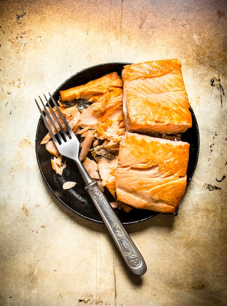 Fried trout at the plate with a fork