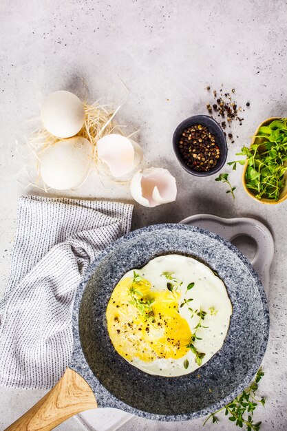 Fried turkey egg in a frying pan, gray background.