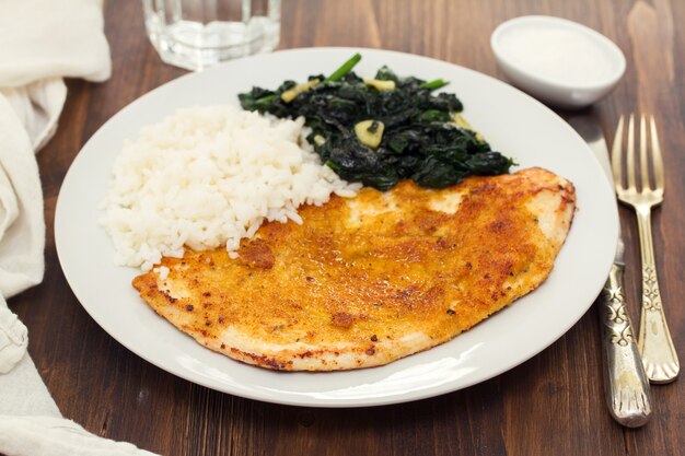 Fried turkey with rice and spinach on the dish