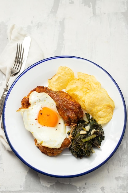 Fried typical portuguese smoked sausage with chips and spinach