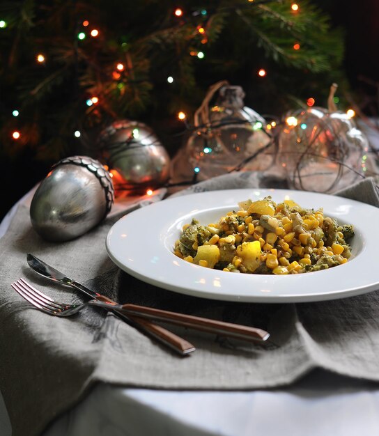 fried vegetables in white plate on Christmas decorations background.