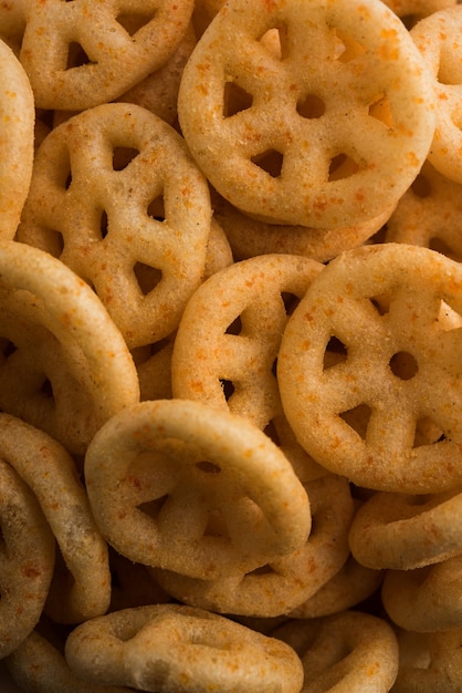 Fried wheel Snacks or Fryums served in a bowl or over moody background. selective focus