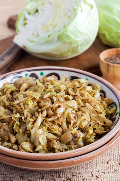 Fried white cabbage with caraway seeds and curry powder on rustic plate