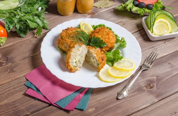 Fried zrazy meat cutlets stuffed with eggs and herbs on a dark wooden background