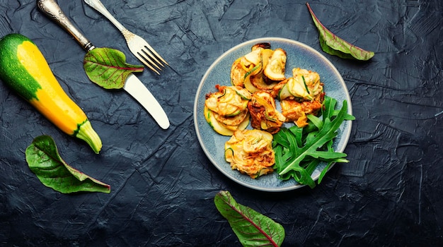 Fried zucchini and fresh herbs on the plate