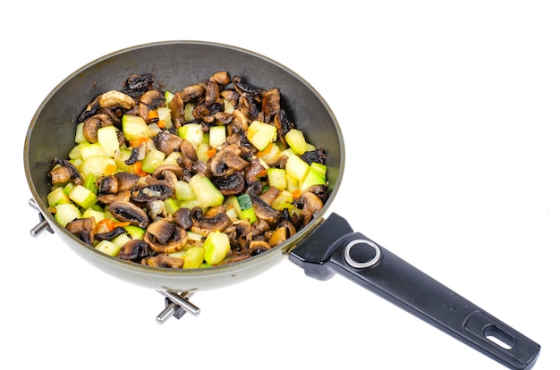 Fried zucchini with mushrooms in pan.