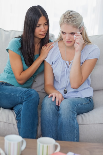 Friend comforting her crying friend