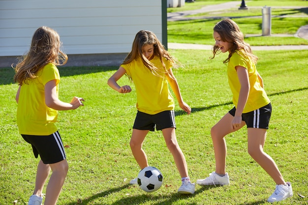 Друг девочек-подростков играет в футбол в парке