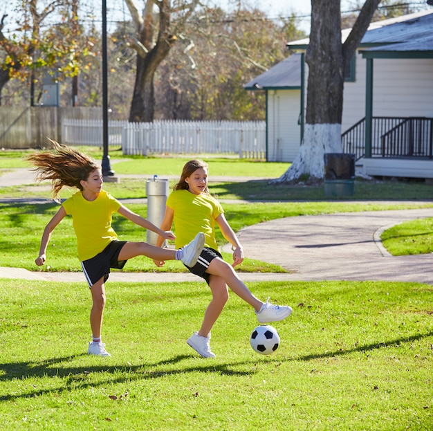 Friend girls teens playing football soccer in a park