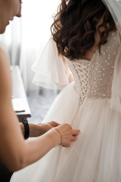 A friend ties a wedding dress on the bride 3982