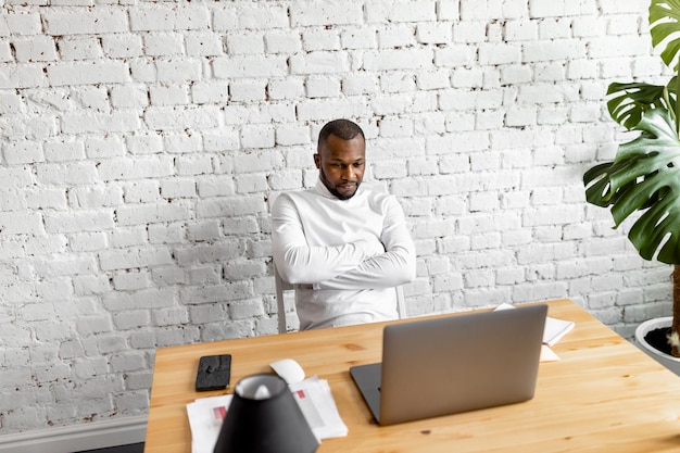 Friendly African American using a laptop looking at the screen chatting with colleagues on a socia