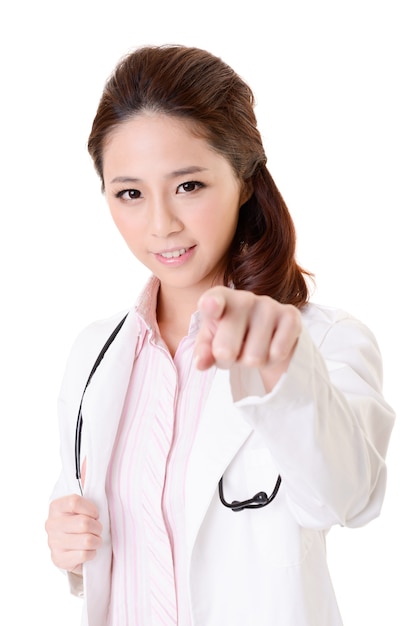 Friendly Asian doctor woman point at you, closeup portrait isolated on white wall.