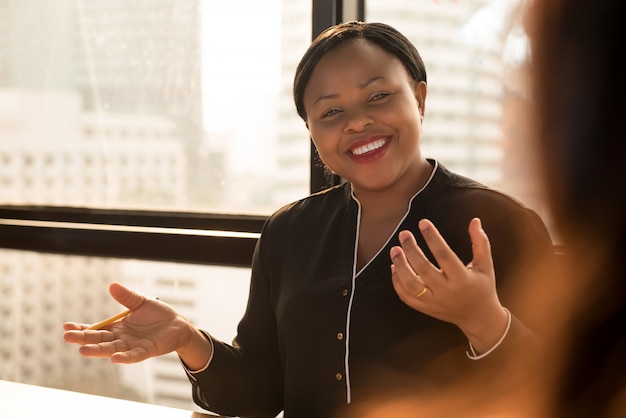 Friendly black businesswoman leader discussing work at the meeting 