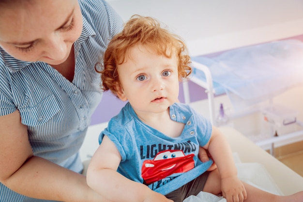 Friendly doctor pediatrician with patient child at clinic