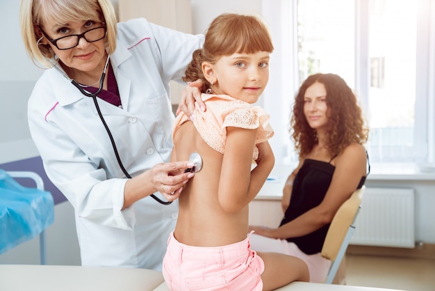 Friendly doctor pediatrician with patient child at clinic