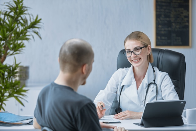A friendly doctor smiles at the patient in a bright and modern medical office