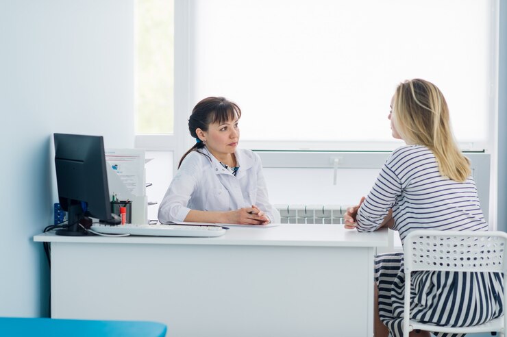 Friendly female doctor comforting middle aged patient in hospital