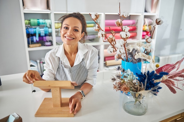 Friendly florist posing behind a counter of a flower shop