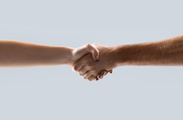 Friendly handshake friends greeting teamwork friendship woman\
two hands helping arm of a friend teamwork closeup helping hand\
outstretched isolated arm salvation girl close up help hand