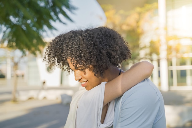 Friendly hug concept smiling millennial black man and woman cuddling friendship and good warm