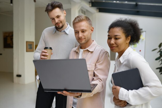 Foto collega amichevole che spiega come correggere facilmente un errore a una collega donna felice. conversazione piacevole con aiuto e supporto sul posto di lavoro durante la pausa caffè