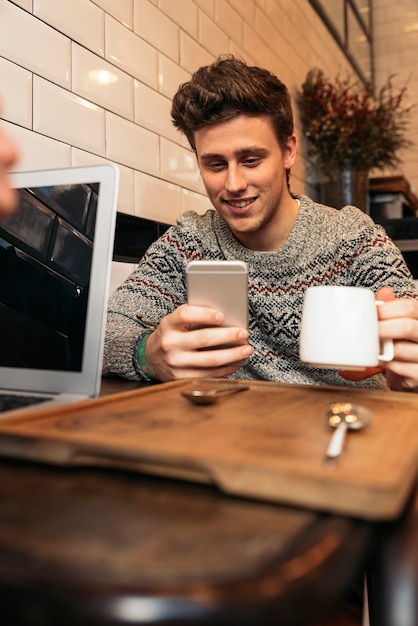 Friendly man using his mobile in the Coffee Shop. Business Concept.