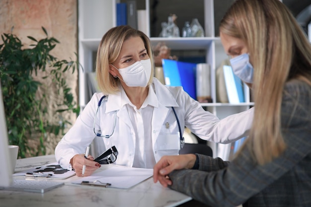 Amichevole dottoressa di mezza età che incoraggia, sostiene il paziente dopo la visita medica.