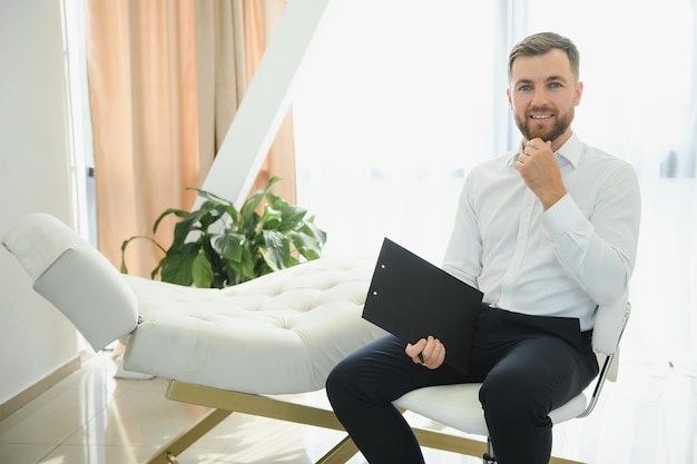 Friendly middle eastern male psychologist smiling at camera during therapy session working in clinic free space Happy psychotherapist posing at office