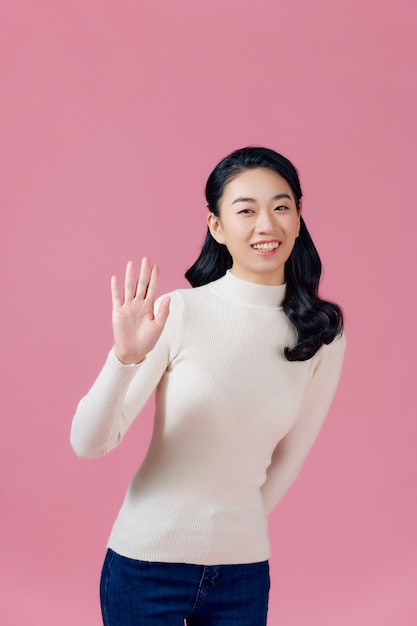 Friendly pleasant and cheerful eastasian woman raising palm wave hand greeting and smiling