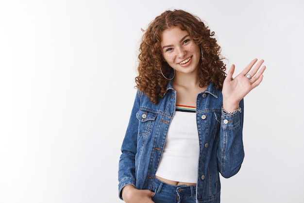 Amichevole ragazza rossa agitando la mano dicendo ciao