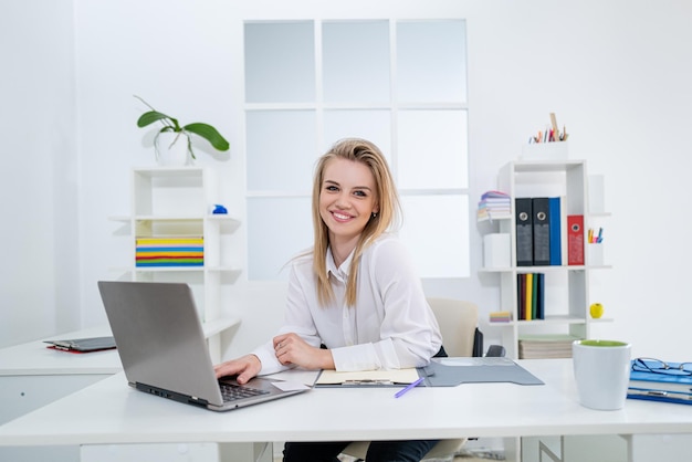 Friendly secretary woman behind the reception desk administrator