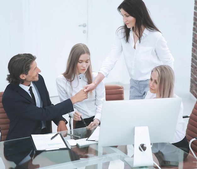 Friendly smiling businessman and businesswoman handshaking over the office desk