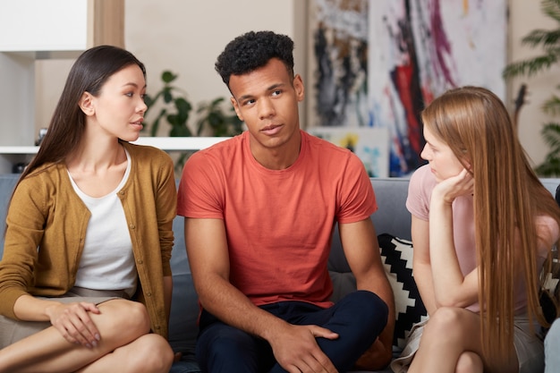 Friendly talk young multicultural friends in casual wear chatting and resting together while