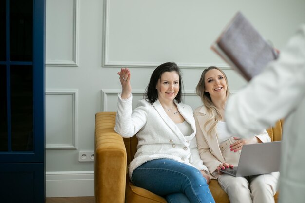 Friendly womens team group of businesswomen are discussing project in office one of them is pregnant