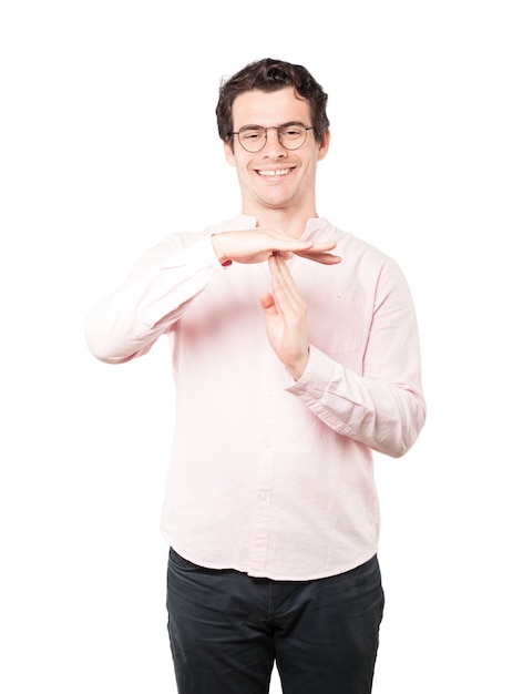 Friendly young man making a time out gesture with his hands