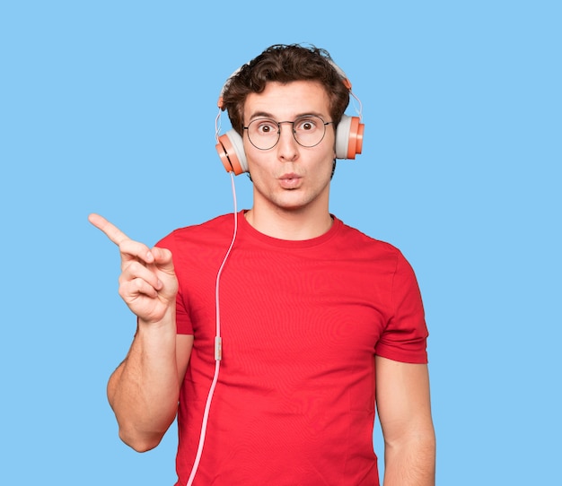 Friendly young man making a wondering gesture and pointing up with his finger