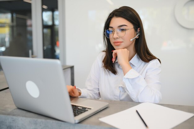 Friendly young woman behind the reception desk administrator