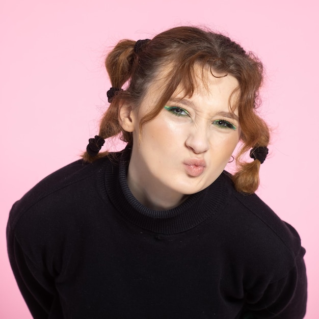 Friendly young woman with a vivacious smile and emotion young redhaired girl on pink background