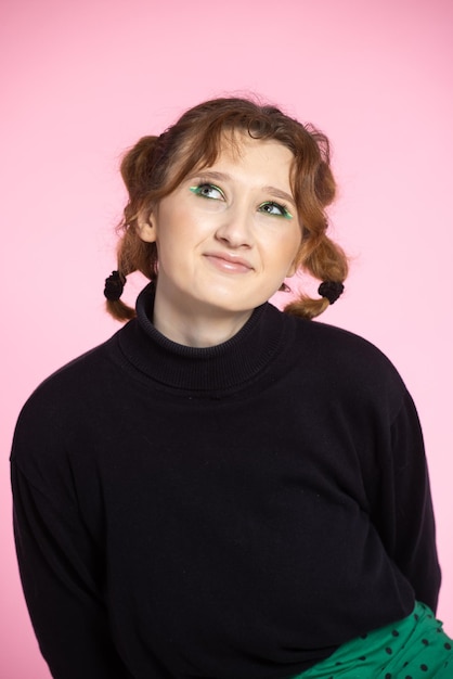 Friendly young woman with a vivacious smile and emotion young redhaired girl on pink background