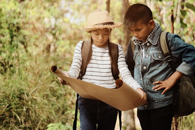 Friends analyzing map while standing in forest