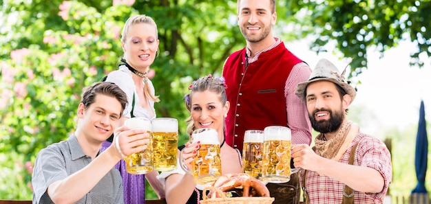 Friends in Bavarian beer garden drinking in summer