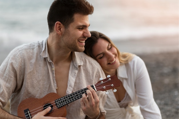 Friends at a beach party with ukulele