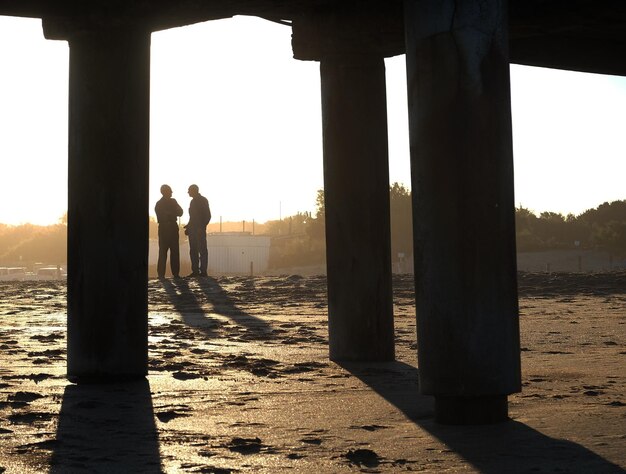 Photo friends in beach pier at sunset