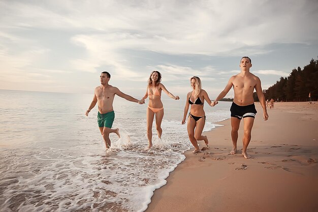 Friends on the beach summer by the sea / cheerful company of\
young friends, summer view