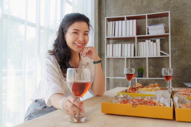 Amici alla festa di compleanno bicchieri tintinnanti con champagne e pizza che si godono la pizza delle vacanze di natale sul tavolo evento festa