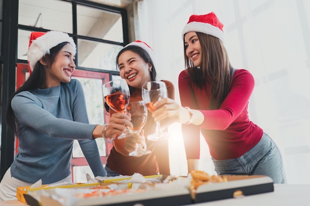 Friends at birthday party clinking glasses with champagne and pizza enjoying Christmas vacation pizza on the table Holiday Party event