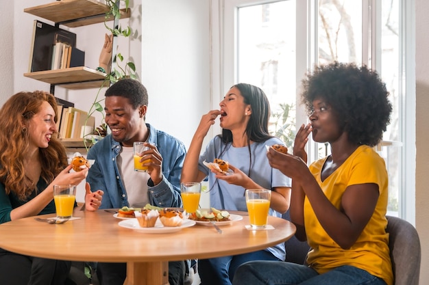 Photo friends at a breakfast with orange juice and muffins at home healthy lifestyle having fun in the morning