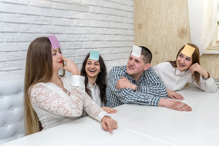 Фотография друзья в кафе играют, кто я, и позируют на камеру